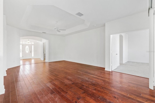 empty room featuring wood-type flooring and ceiling fan with notable chandelier