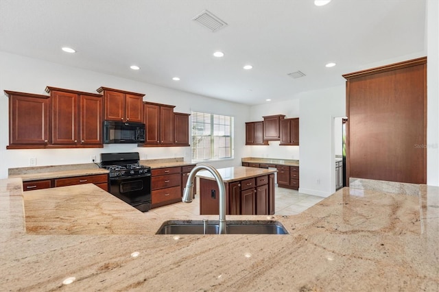 kitchen featuring light tile patterned floors, sink, light stone counters, and black appliances