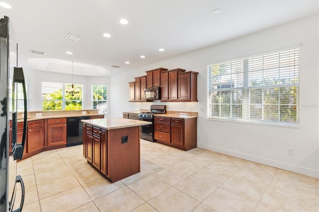 kitchen with hanging light fixtures, a kitchen island, light stone counters, light tile patterned flooring, and black appliances