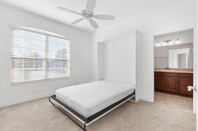 bedroom with light carpet, ensuite bath, ceiling fan, and sink