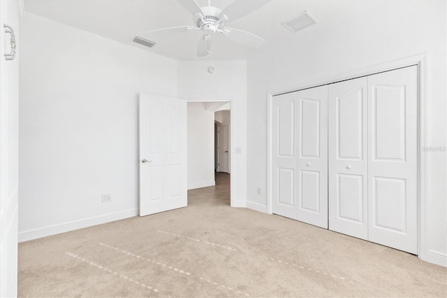 unfurnished bedroom with ceiling fan, a closet, and light colored carpet