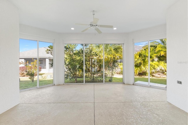 unfurnished sunroom with ceiling fan