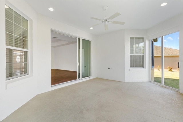 unfurnished sunroom with ceiling fan