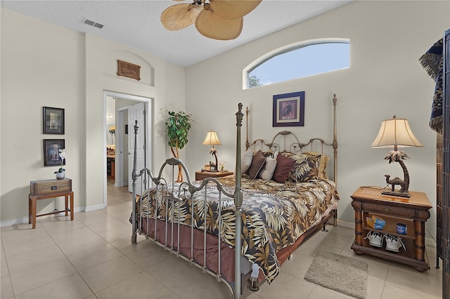 tiled bedroom featuring a towering ceiling, a textured ceiling, and ceiling fan