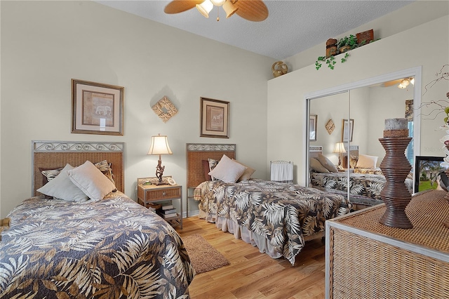 bedroom featuring a textured ceiling, light hardwood / wood-style floors, a closet, and ceiling fan