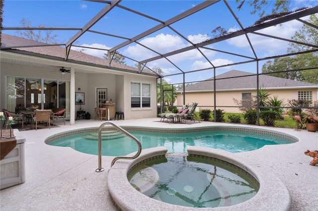 view of pool with glass enclosure, ceiling fan, a patio area, and an in ground hot tub