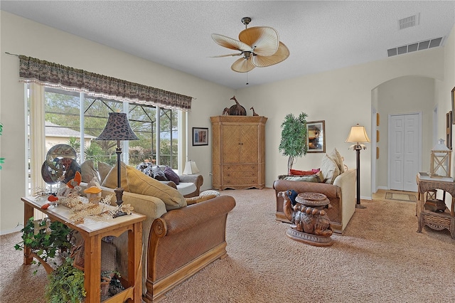 living room featuring ceiling fan, carpet, and a textured ceiling