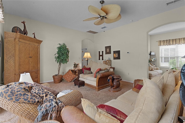 living room with ceiling fan, carpet floors, and a textured ceiling