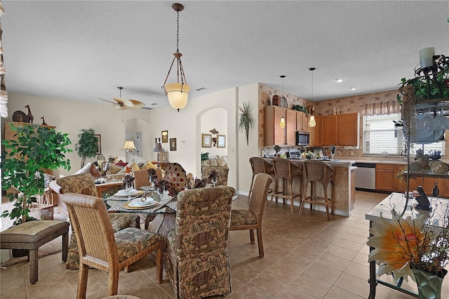 dining area featuring light tile patterned floors, a textured ceiling, and ceiling fan