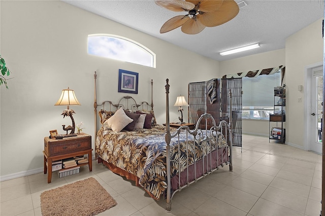 tiled bedroom with a textured ceiling and ceiling fan