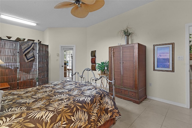 bedroom with ceiling fan, light tile patterned flooring, and a textured ceiling