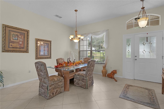 dining space with light tile patterned floors, a chandelier, and a textured ceiling