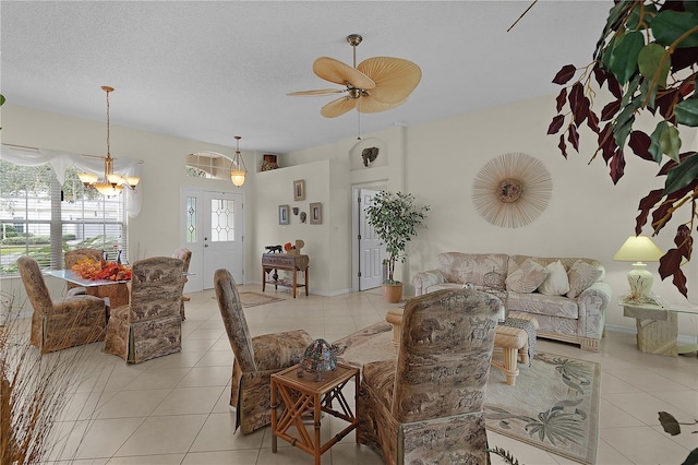 tiled living room with a textured ceiling and ceiling fan with notable chandelier