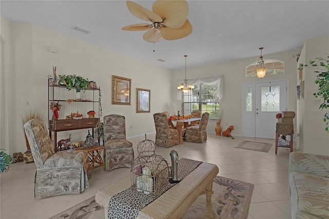 living room featuring a textured ceiling, ceiling fan with notable chandelier, and light tile patterned flooring