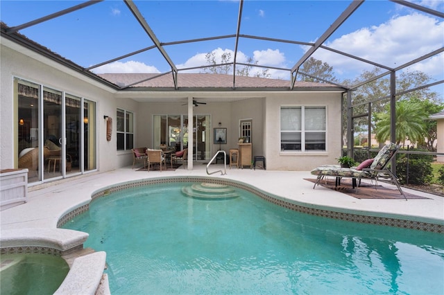 view of pool with a lanai, ceiling fan, a patio area, and a jacuzzi