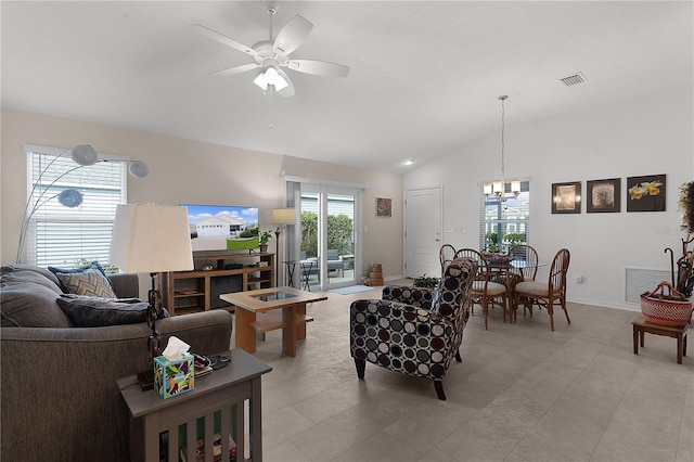 tiled living room with ceiling fan with notable chandelier and vaulted ceiling