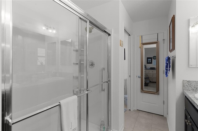 bathroom with tile patterned flooring, vanity, and a shower with shower door