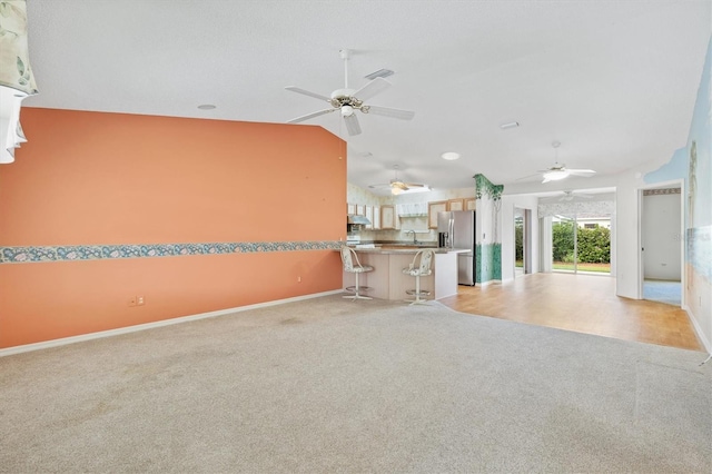 unfurnished living room with light colored carpet and lofted ceiling