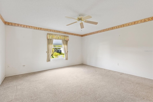 carpeted spare room featuring ceiling fan and a textured ceiling