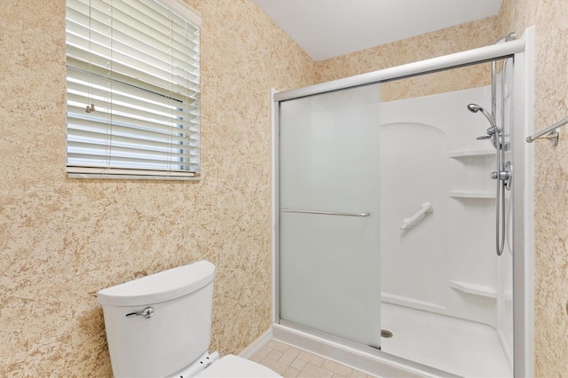 bathroom with toilet and a shower with shower door