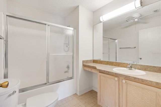 full bathroom featuring ceiling fan, combined bath / shower with glass door, a textured ceiling, toilet, and vanity