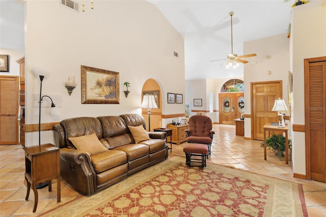 tiled living room with high vaulted ceiling and ceiling fan