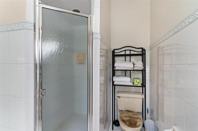 bathroom with walk in shower, toilet, and tile walls