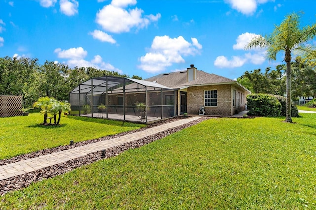 rear view of house with a lanai, a yard, and a pool