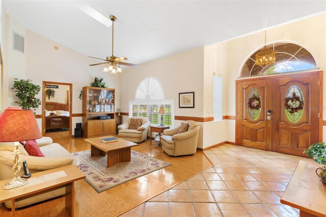 living room featuring light tile patterned floors and ceiling fan with notable chandelier