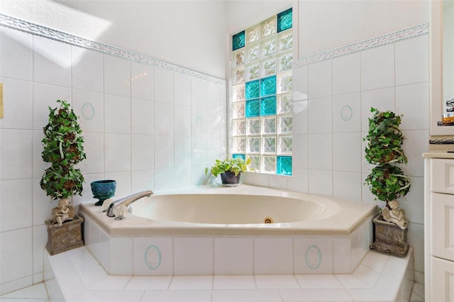 bathroom with vanity, tile walls, and tiled bath