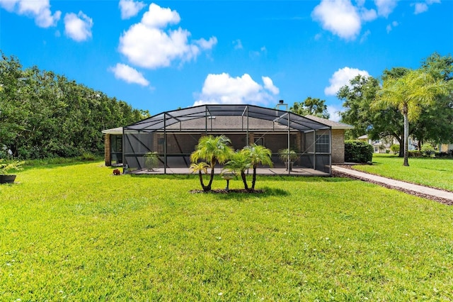 rear view of house featuring a lawn and glass enclosure