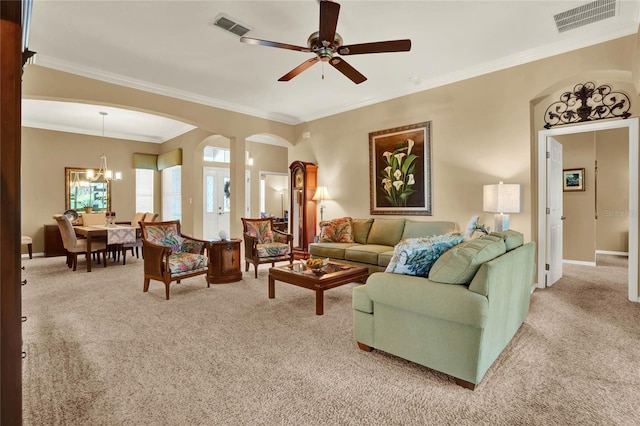 carpeted living room with ceiling fan with notable chandelier and ornamental molding