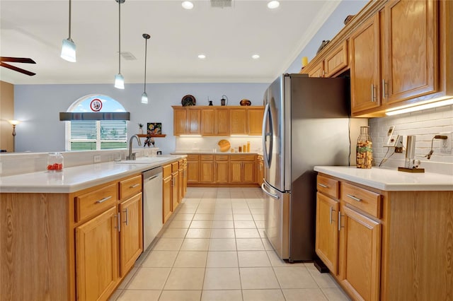 kitchen featuring ceiling fan, stainless steel appliances, pendant lighting, a kitchen island with sink, and ornamental molding