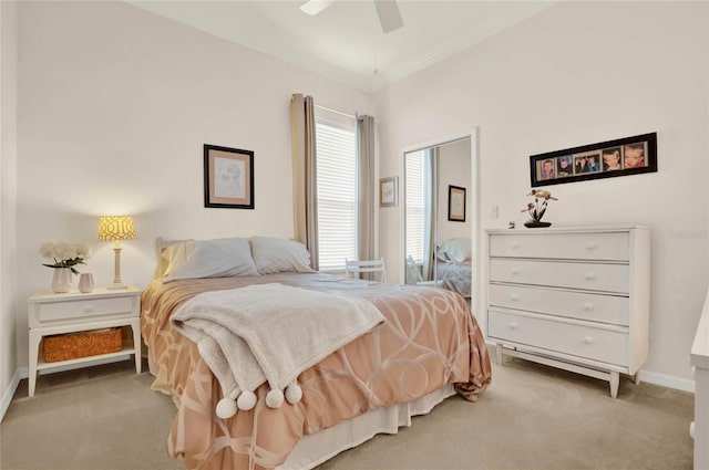 bedroom featuring ceiling fan, crown molding, and light colored carpet