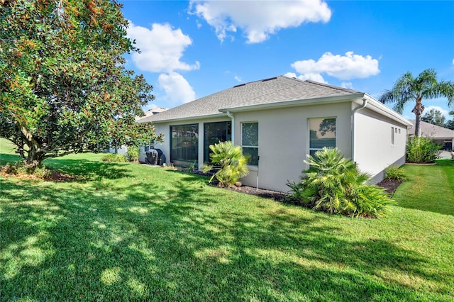 rear view of property featuring a lawn