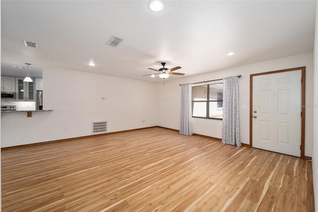 unfurnished living room with ceiling fan and light wood-type flooring