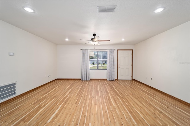 unfurnished room featuring ceiling fan, light hardwood / wood-style floors, and a textured ceiling