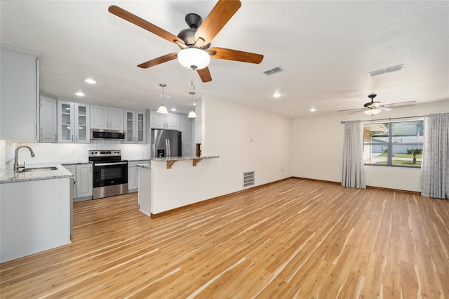 kitchen featuring sink, white cabinets, stainless steel appliances, and light hardwood / wood-style flooring