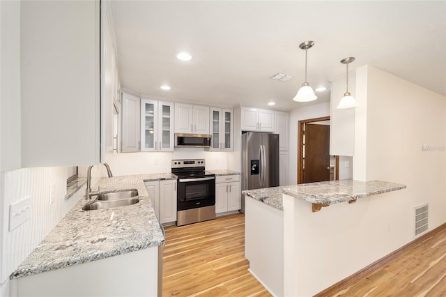 kitchen featuring white cabinets, sink, light wood-type flooring, kitchen peninsula, and stainless steel appliances