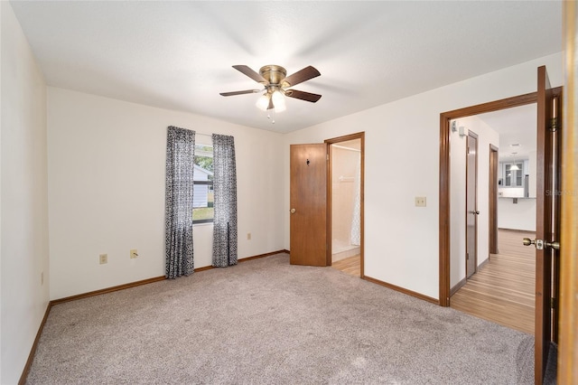 unfurnished bedroom featuring light colored carpet, ceiling fan, and ensuite bathroom