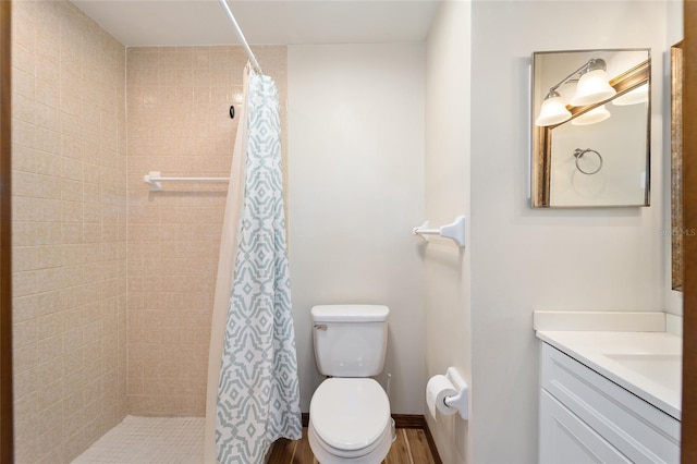 bathroom with hardwood / wood-style floors, vanity, toilet, and curtained shower