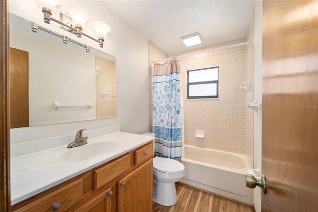 full bathroom with shower / bath combo with shower curtain, hardwood / wood-style floors, vanity, and toilet