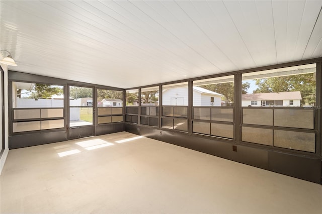 unfurnished sunroom featuring a healthy amount of sunlight and vaulted ceiling