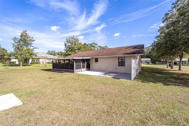 back of house featuring a lawn, a sunroom, and a patio