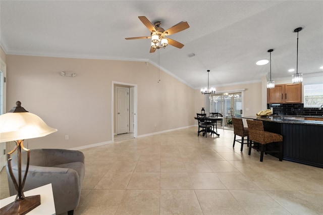 kitchen with lofted ceiling, backsplash, dark countertops, a kitchen bar, and crown molding