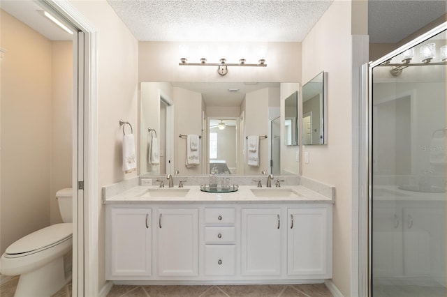 full bathroom with a sink, a shower stall, toilet, and double vanity