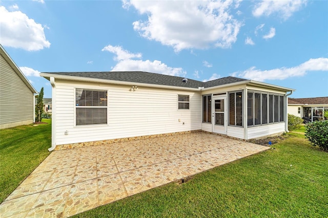 back of property with a patio area, a lawn, and a sunroom