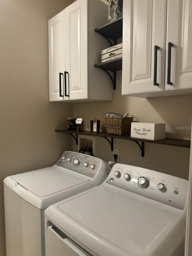 laundry area with independent washer and dryer and cabinet space