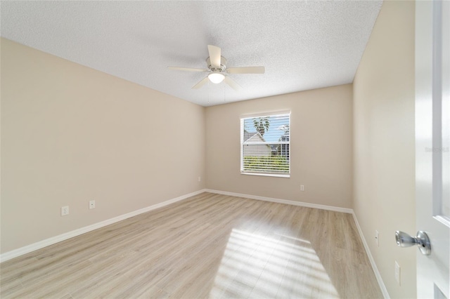 unfurnished room with a ceiling fan, baseboards, a textured ceiling, and light wood finished floors