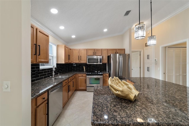 kitchen featuring ornamental molding, stainless steel appliances, hanging light fixtures, and a sink